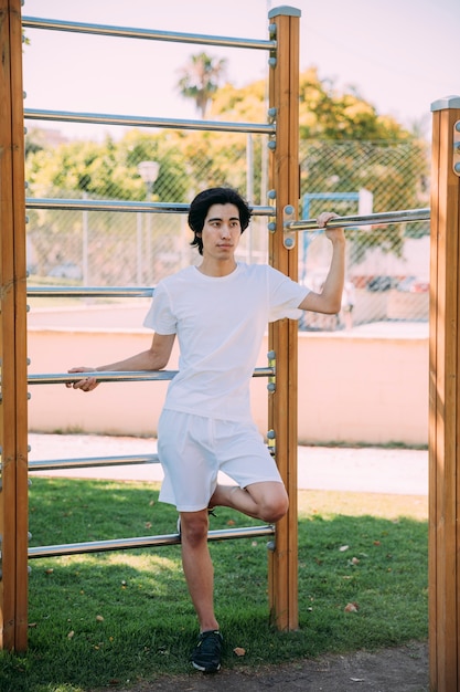 Asian young man resting at jungle gym