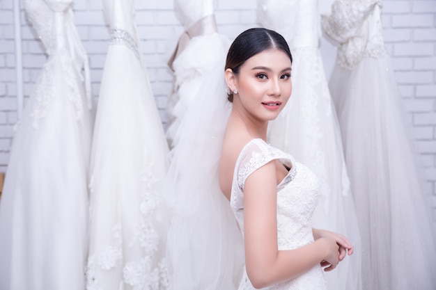 Asian young woman bride trying on wedding dress at modern wedding