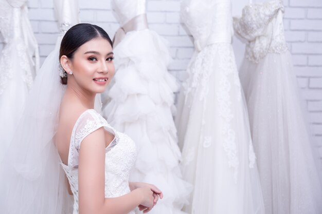 Asian young woman bride trying on wedding dress at modern wedding