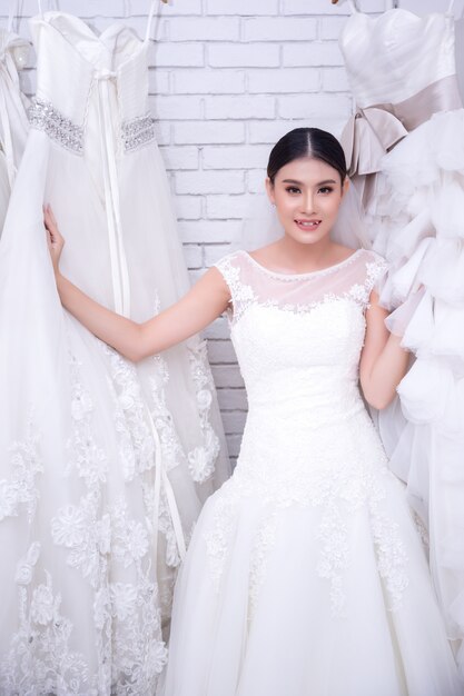 Asian young woman bride trying on wedding dress at modern wedding