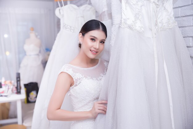 モダンな結婚式でウェディングドレスを試着しているアジアの若い女性の花嫁