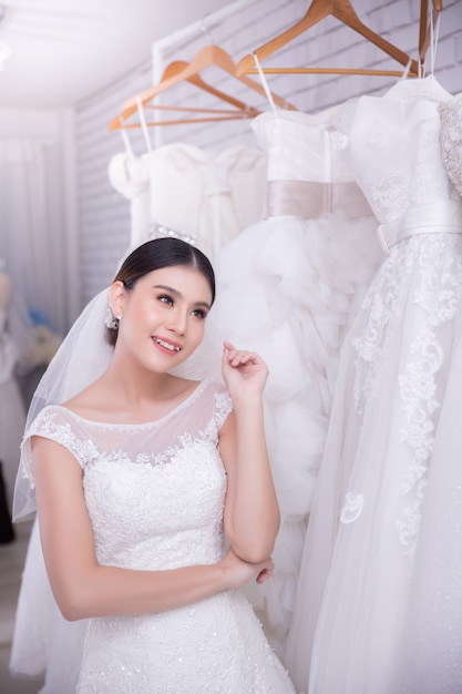 モダンな結婚式でウェディングドレスを試着しているアジアの若い女性の花嫁