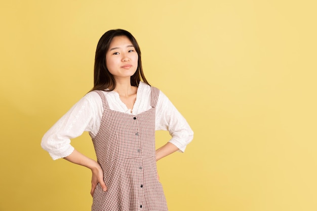 Asian young woman's portrait on yellow studio background Concept of human emotions facial expression youth sales ad