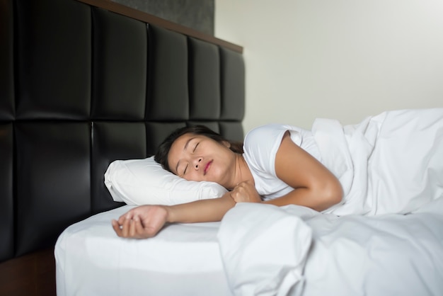 Asian young woman sleeping lying in bed