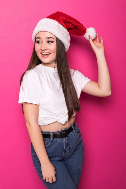 Asian young woman wearing Santa's hat isolated on pink wall