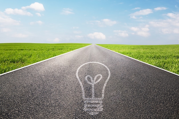 Asphalt road with a light bulb painted