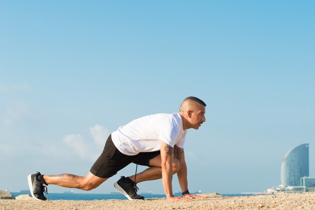 Aspirated runner in starting position on beach