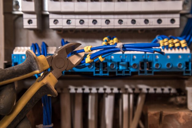 Assembly of the electrical panel, electrician job, a robot with wires and circuit breakers