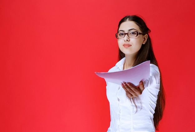 Assistant in eyeglasses returning the exam sheets.