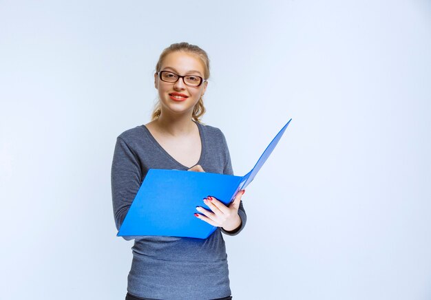 Assistant opening the blue report folder and checking it.