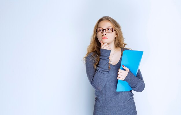 Assistant with blue folder looks dissatisfied.