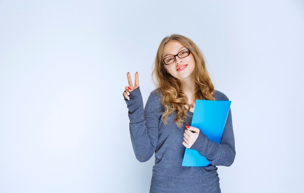 Assistant with a blue folder showing successful sign.