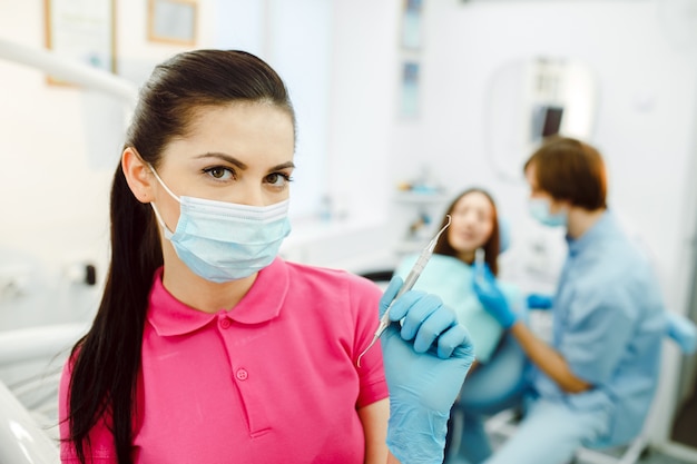 Assistant with mask and a dental tool