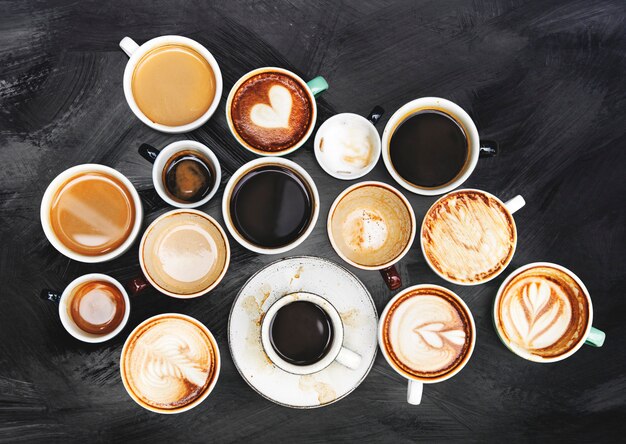 Assorted coffee cups on a textured background