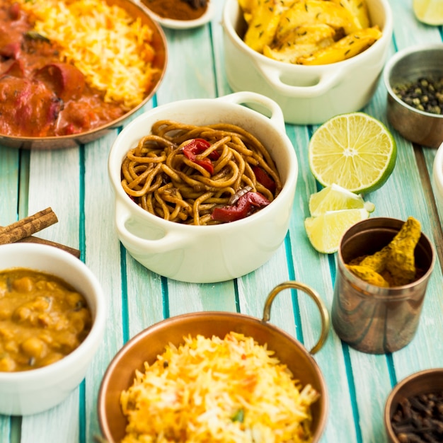 Assorted dishes and spices near pasta and lime