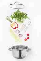 Free photo assorted fresh vegetables falling into a bowl, on white