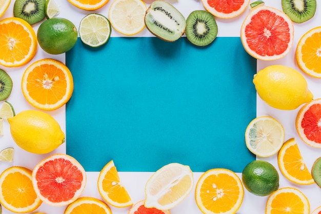 Assorted fruits around blue paper sheet