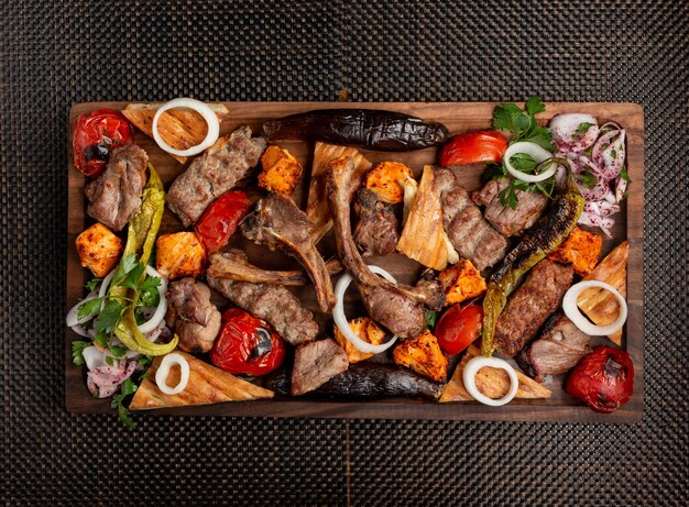 Assorted meat kebab with onions herbs and grilled vegetables