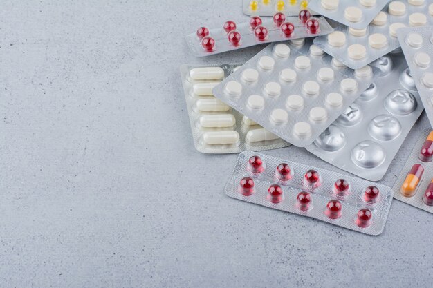 Assorted packs of medical drugs on marble background. 