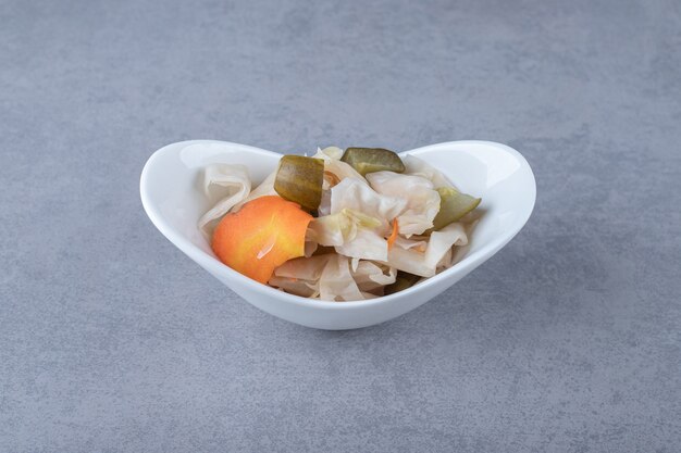 Assorted pickled vegetables in bowl , on the marble background.