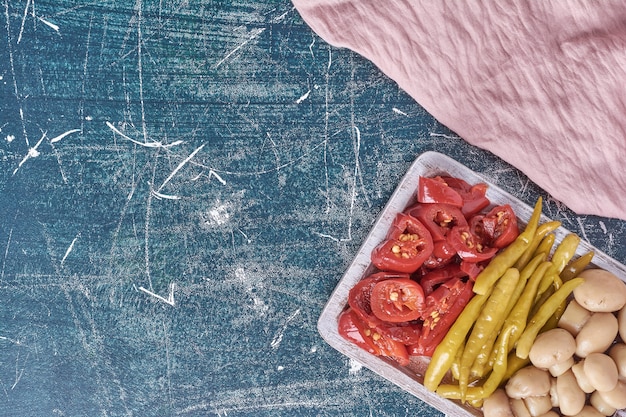 Assorted pickled vegetables on white plate with tablecloth. 