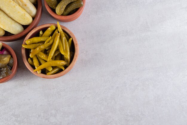 Бесплатное фото Ассорти из солений из овощей на каменном фоне.