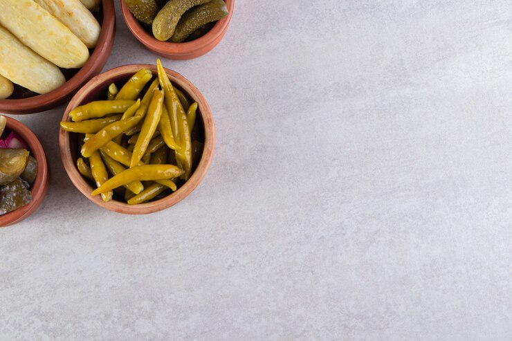 Free Photo assorted pickles vegetables placed on a stone background.