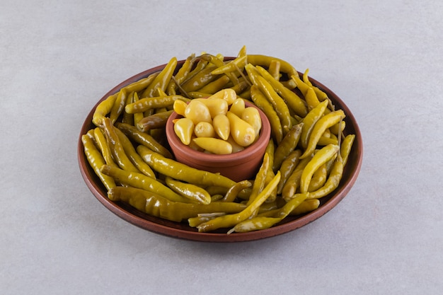 Assorted pickles vegetables placed on a stone surface. 