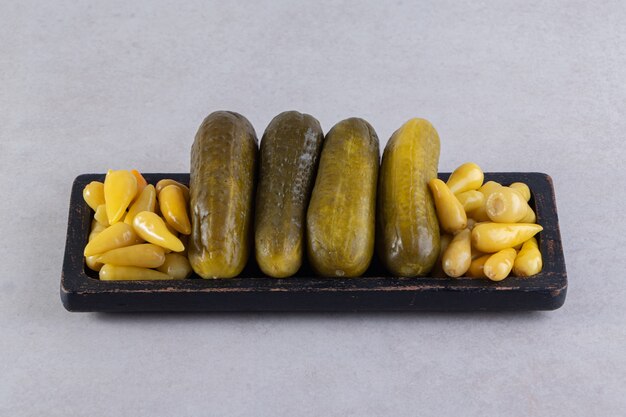 Assorted pickles vegetables placed on a stone surface. 