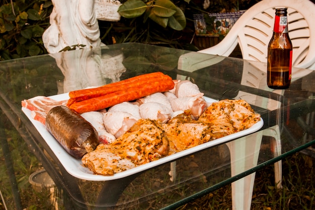 Foto gratuita carne cruda assortita sul vassoio sopra il tavolo di vetro