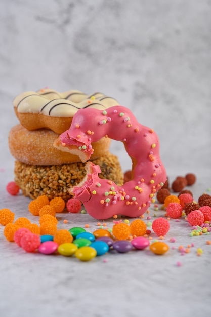모듬 된 스택 도넛과 딸기 무는 도넛이 앞에 놓여 있습니다.