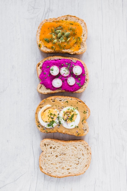 Foto gratuita tartine assortite vicino al pane