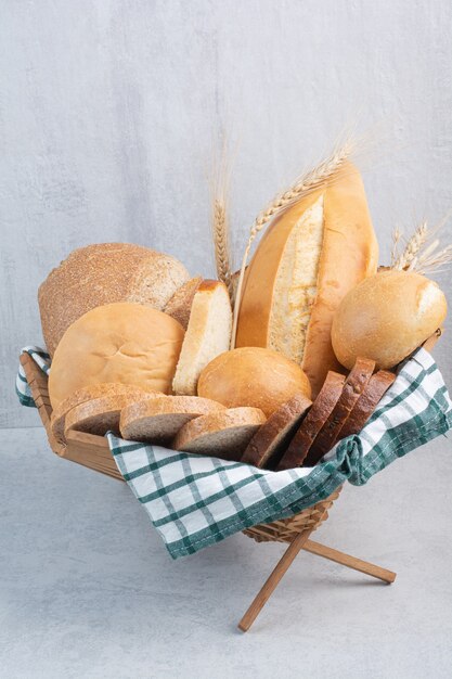 Assortment of bread in basket on marble surface