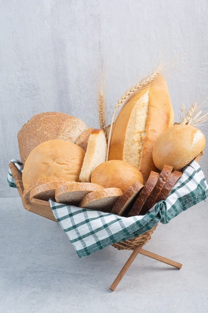 Assortment of bread in basket on marble surface