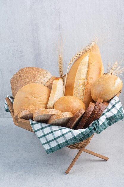 Ассортимент хлеба в корзине на мраморной поверхности