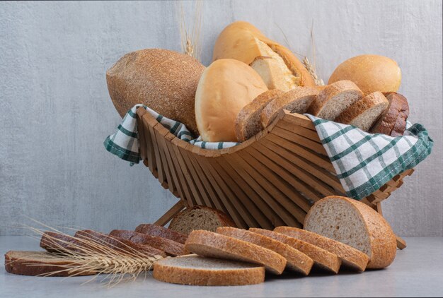Assortment of bread in basket on marble surface