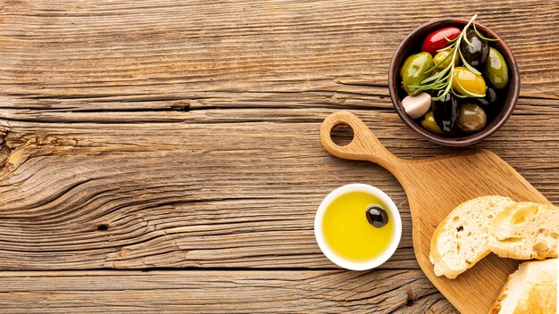 Assortment of colorful olives with oil saucer and copy space