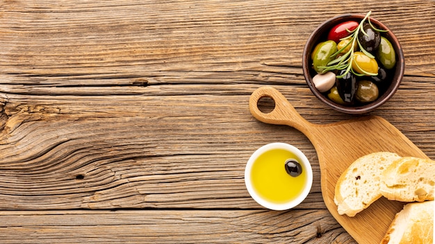 Assortment of colorful olives with oil saucer and copy space