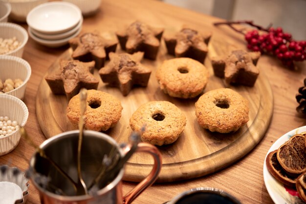 Assortment of cookies on wooden board with winterberry