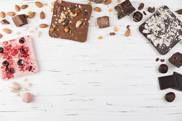 Assortment of delicious chocolate on wooden white background 