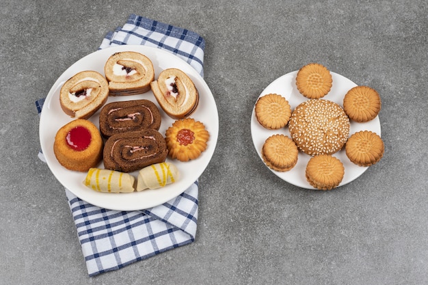 Assortment of delicious cookies on white plates