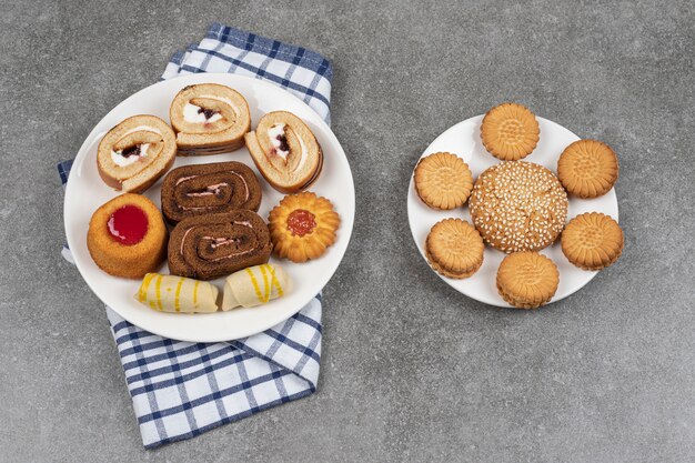 Assortment of delicious cookies on white plates
