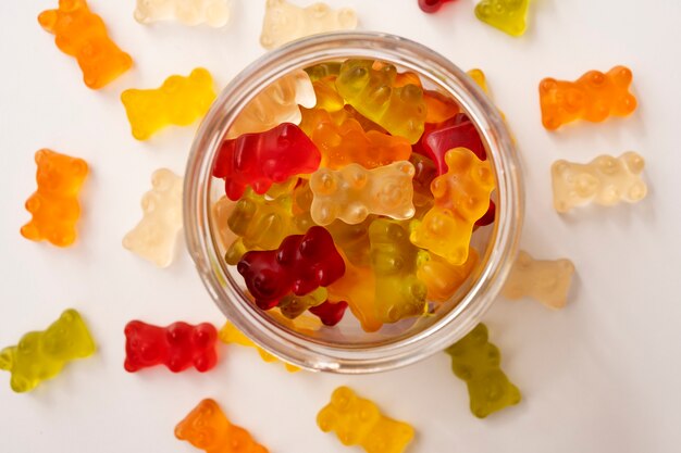 Assortment of delicious gummy bears with glass jar