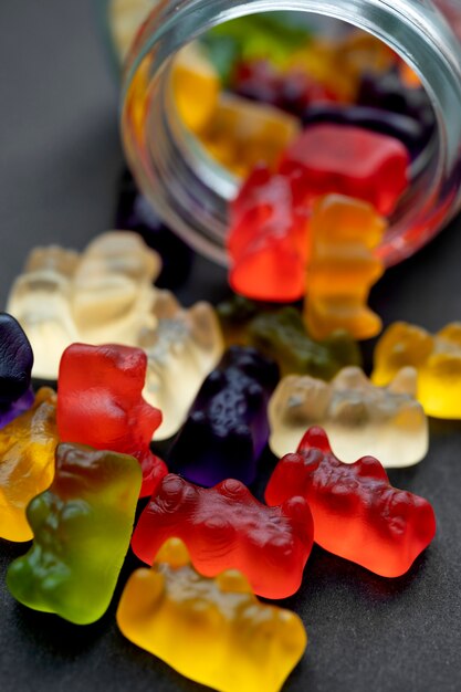 Assortment of delicious gummy bears with glass jar