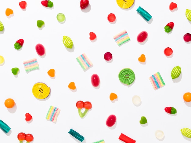 Assortment of different colored candies on white background