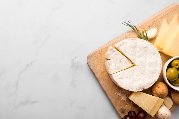 Assortment of different delicacies on wooden board with copy space