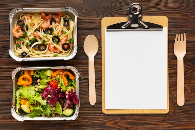 Assortment of different meals with empty clipboard