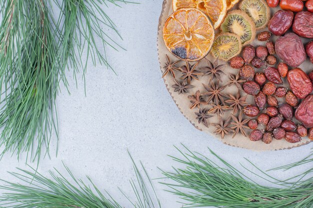 Free photo assortment of dried fruits and cloves on wooden piece.