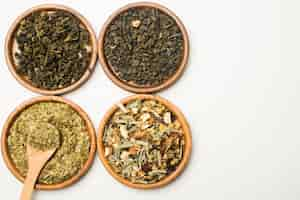 Free photo assortment of dry medicinal herbs wooden circular plates on white backdrop