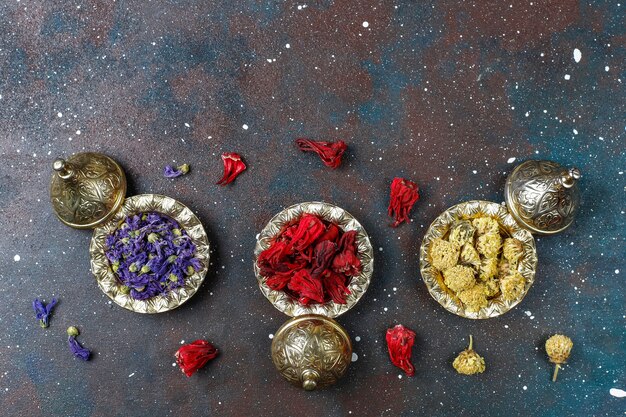 Assortment of dry tea in golden vintage mini plates. Tea types background